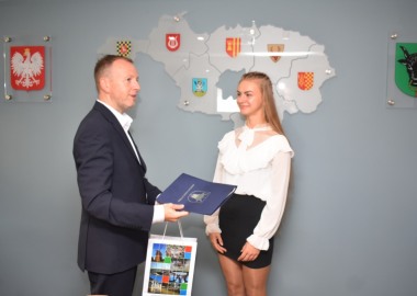 Wicestarosta Maciej Wiśniewski wręcza upominki powiatowe Wiktorii Miturze