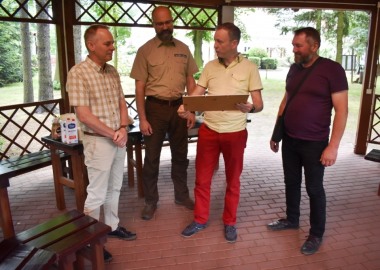 Wicestarosta Maciej Wiśniewski wręcza upominek powiatowy nadleśniczemu Nadleśnictwa Karczma Borowa Jackowi Napieralskiemu