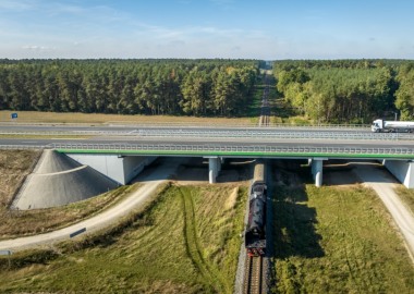 Lokomotywa parowa przejeżdżająca pod wiaduktem drogi ekspresowej S5 w Wilkowicach